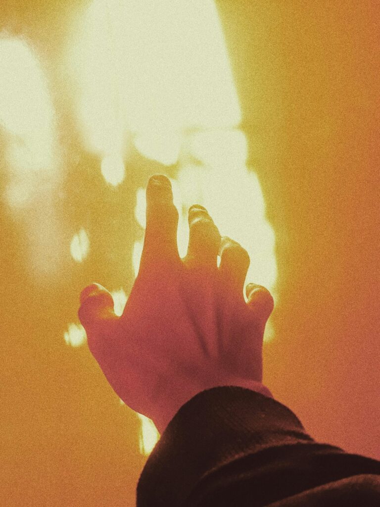 Hand reaching toward a bright golden light, symbolizing transformation, empowerment, and the pursuit of freedom through strategic wealth and trust creation.